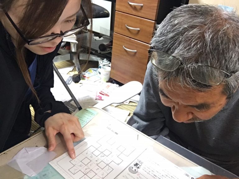 職員が入居者に対して書類や図表を使った個別支援を行っている様子